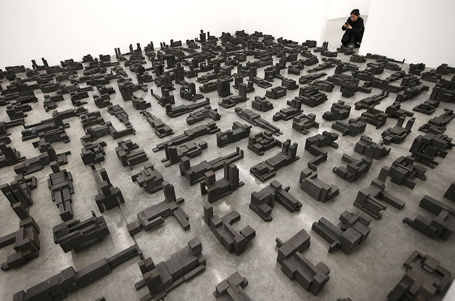 A member of the gallery takes a photograph of a piece called "Sleeping Field", by artist Antony Gormley, which forms part of an exhibition entitled "Fit", at the White Cube gallery in London, Britain September 29, 2016.   REUTERS/Peter Nicholls