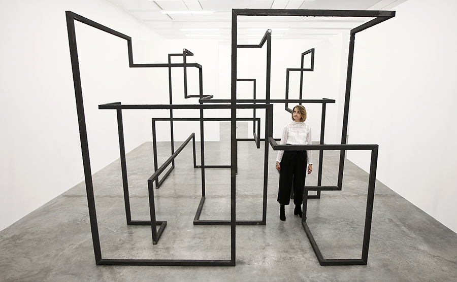 A member of the gallery staff poses for a photograph with a piece called "Run", by artist Antony Gormley, which forms part of an exhibition entitled "Fit", at the White Cube gallery in London, Britain September 29, 2016. REUTERS/Peter Nicholls